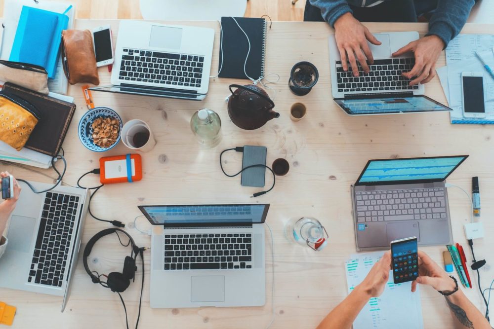Workspace with various laptops working on sales and marketing projects