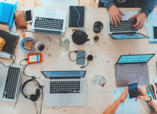 Workspace with various laptops working on sales and marketing projects